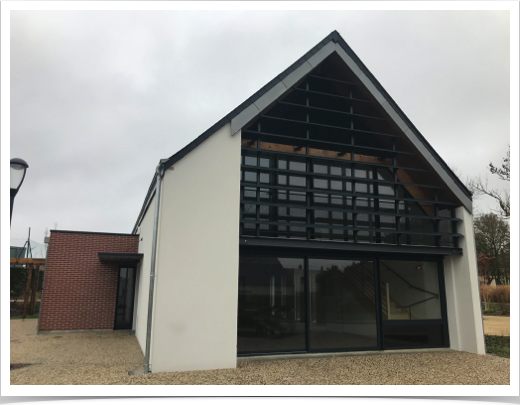 Lames brise soleil type aile d'avion devant mur rideau